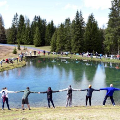 Young ignatian girls and boys gather around a small lake to celebrate the care for creation