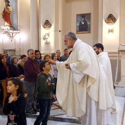 Un padre gesuita e un bambino durante una celebrazione presso la Chiesa del SS. Crocifisso dei Miracoli a Catania