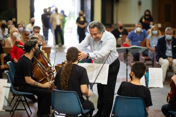 Conductor Riccardo Muti jokes with young musicians from the Musica Libera Tutti orchestra